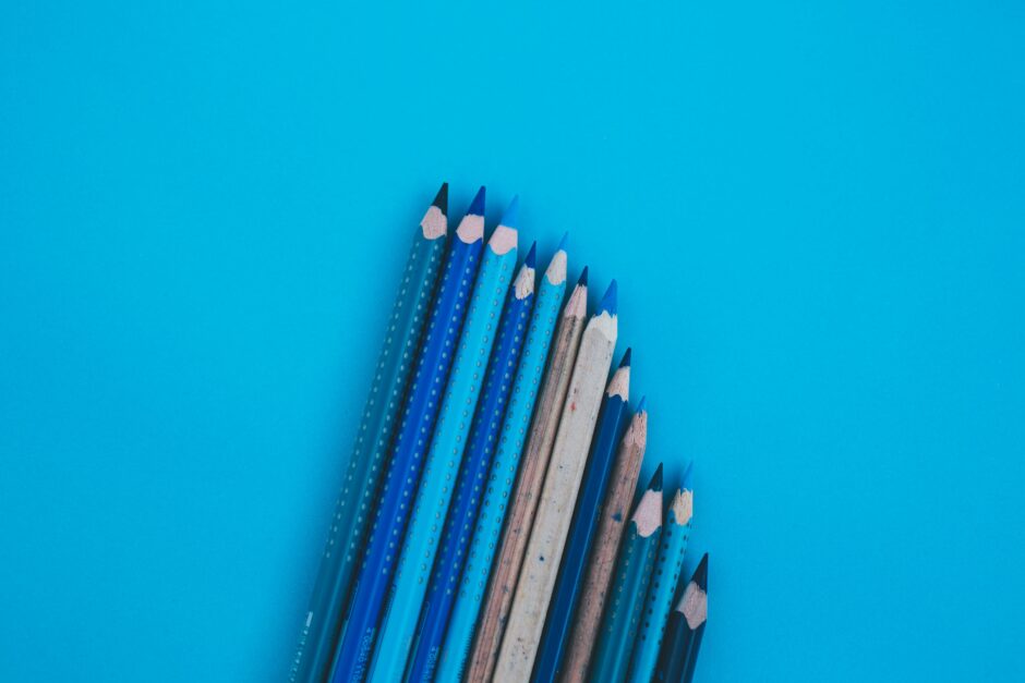 blue and white pencils on green surface